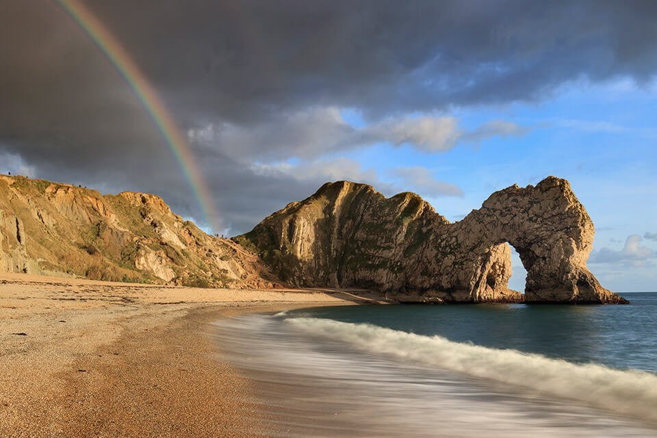 A rainbow arcs over the iconic Durdle Door as captured by Mark Bauer Photography